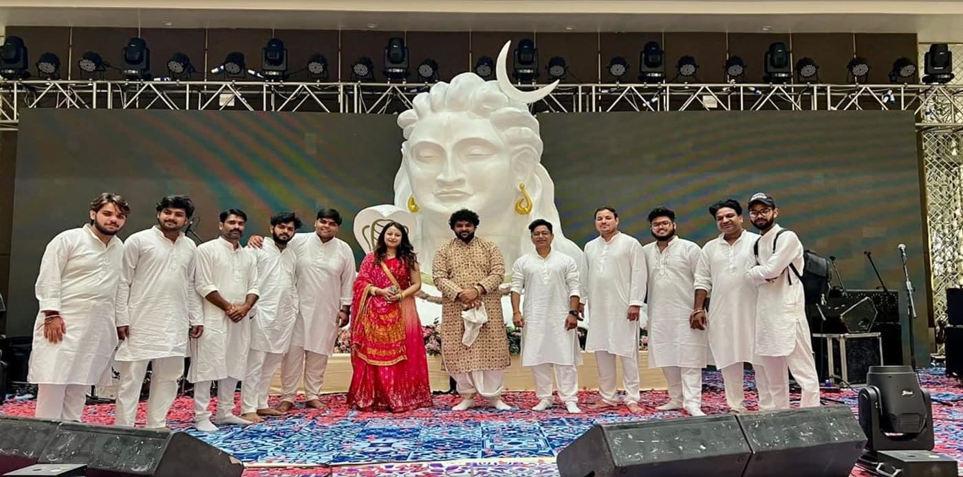 RV Band members standing together on stage in front of a large Shiva statue