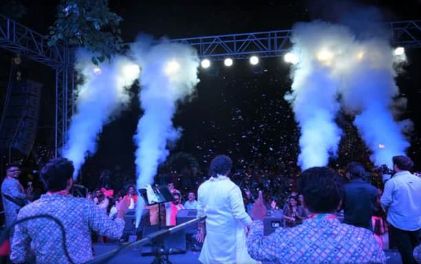 RV Band performing live at a concert with stage lights and a large crowd