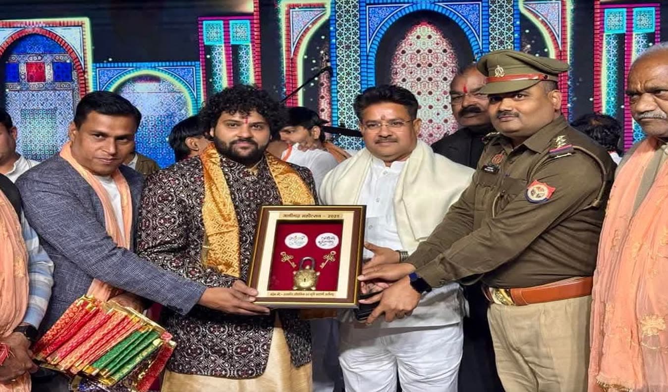 Pt. Govinda Sharma receiving a framed memento on stage