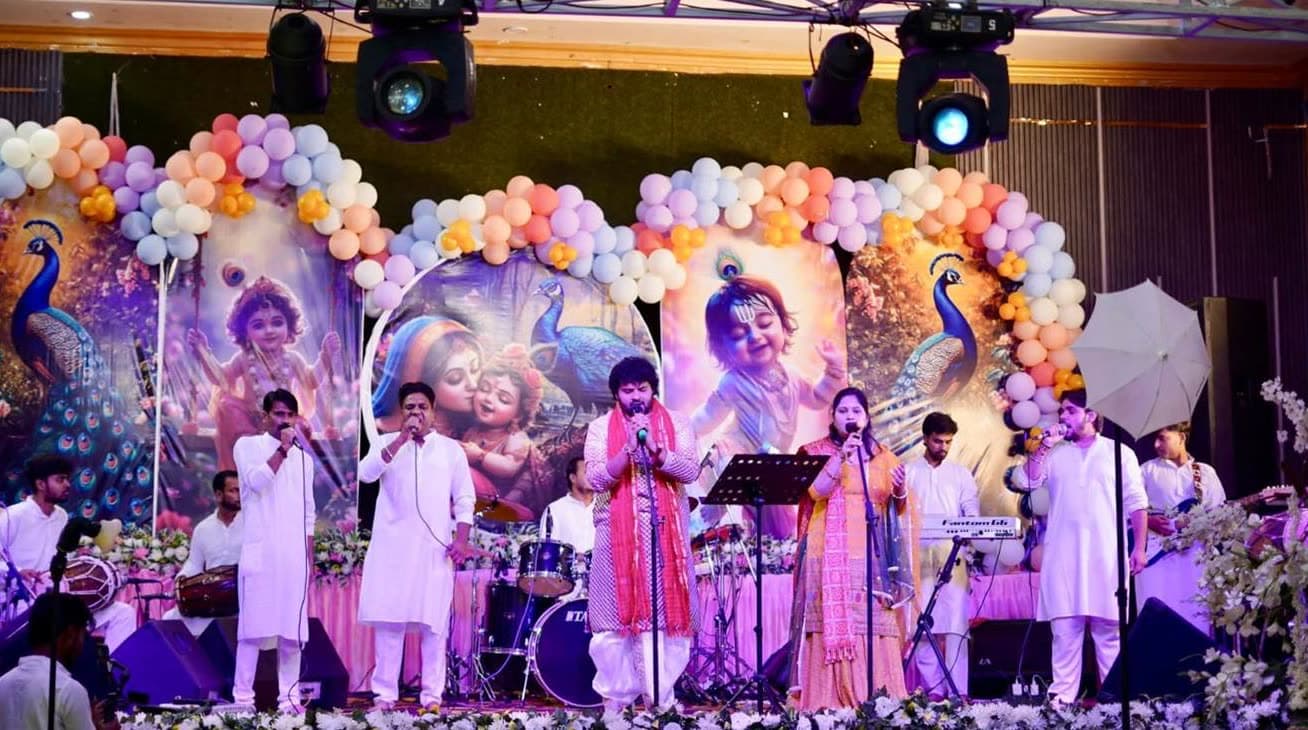 RV Band singing on a stage decorated with balloons and Krishna artwork
