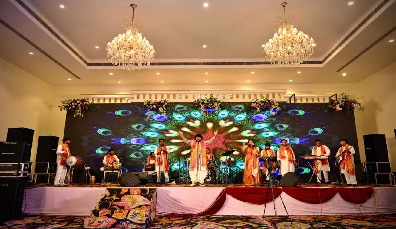 RV Band performing on a stage with a peacock-feather LED screen in a banquet hall